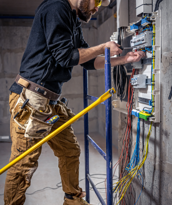 male-electrician-works-switchboard-with-electrical-connecting-cable 1